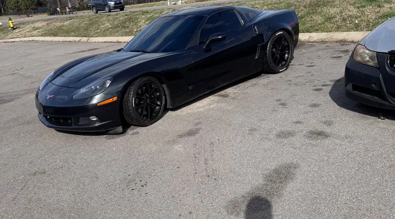 Black C6 Corvette with dark tinted windows in a lot