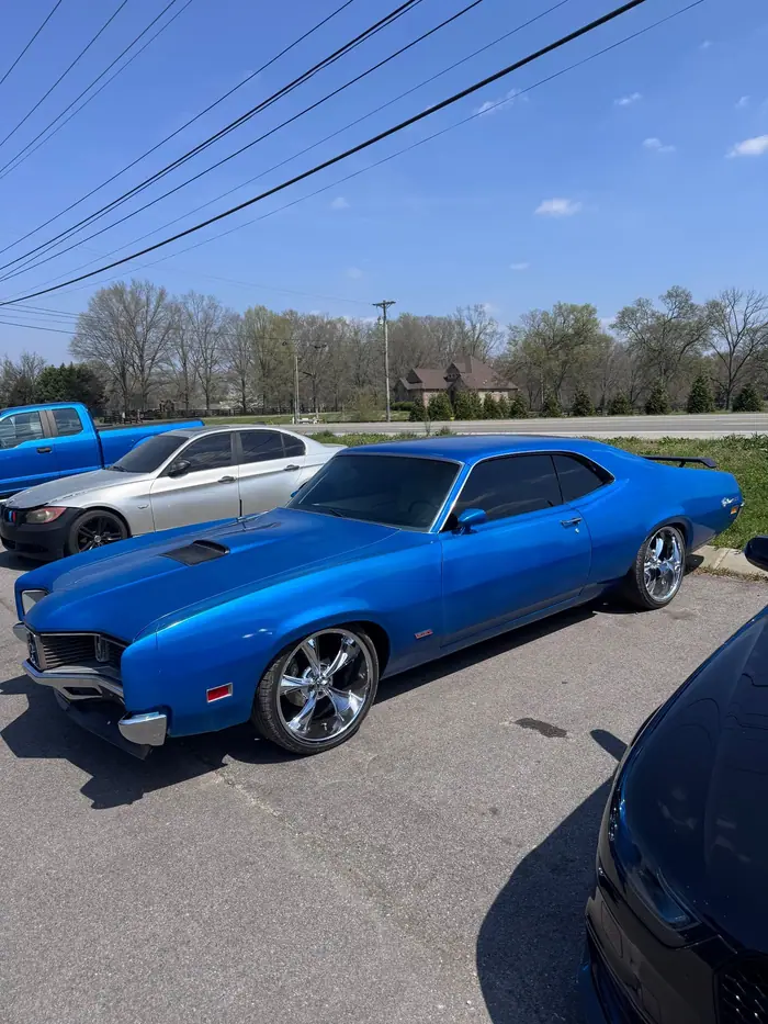 Blue classic muscle car with chrome wheels and tinted glass