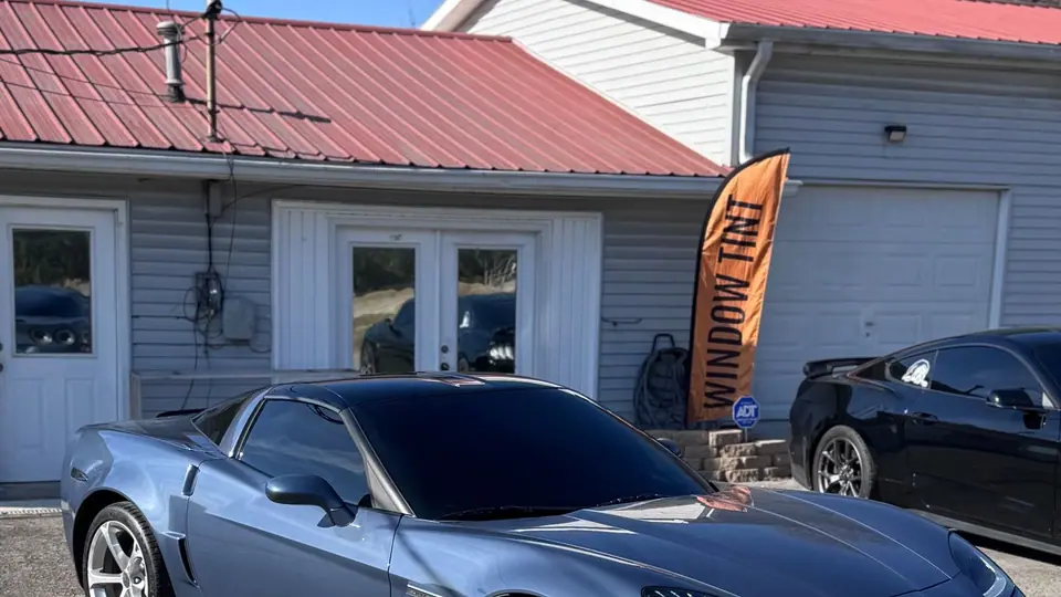 Blue Corvette Grand Sport with dark tinted glass outside the Stealth Tint and PPF shop on Highway 109