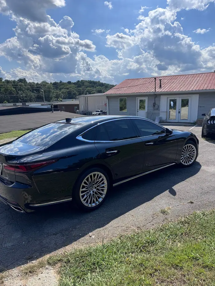 Black Lexus LS sedan with tinted windows outside the shop on Highway 109
