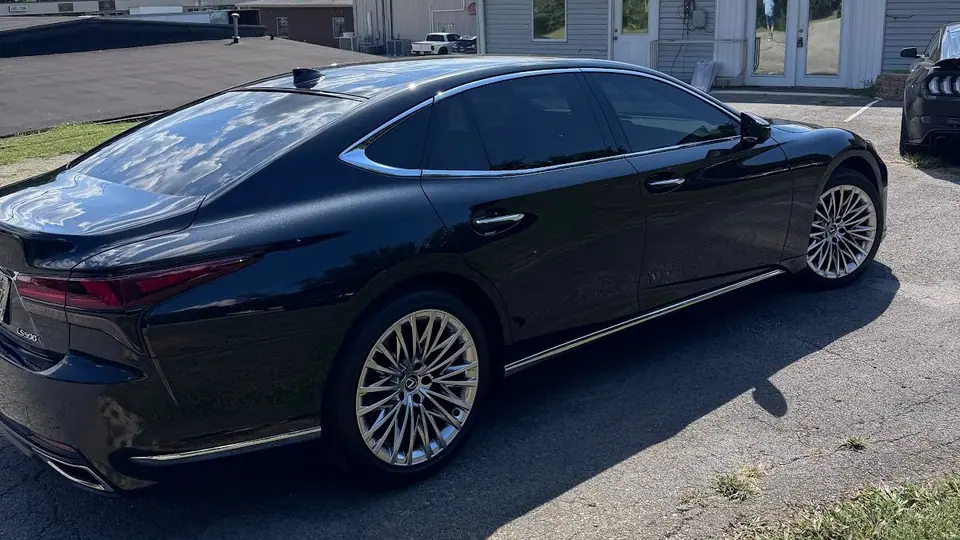 Black Lexus LS with tinted windows outside the Stealth Tint and PPF shop