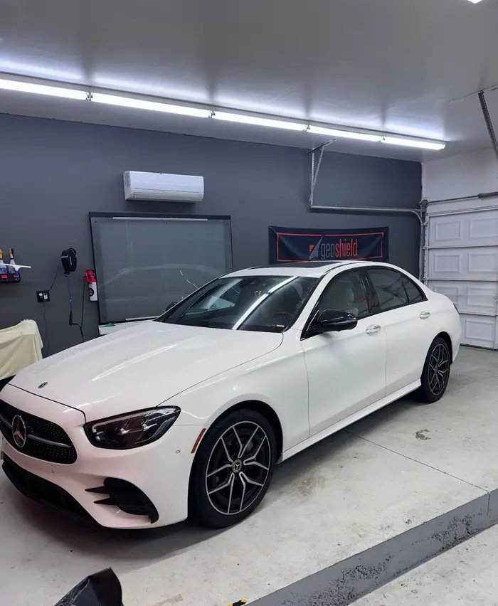 White Mercedes-Benz E-Class with tinted windows in the Stealth Tint and PPF bay