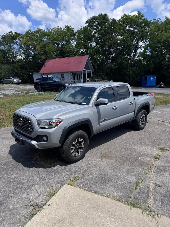 Silver Toyota Tacoma with tinted windows outside the shop