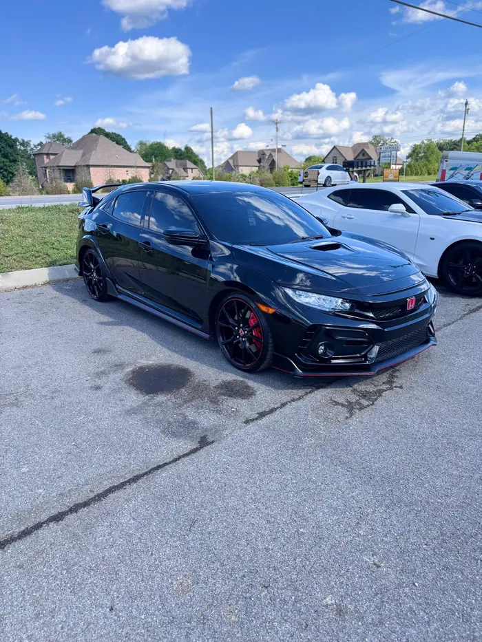 Black Honda Civic Type R with dark window tint in a parking lot